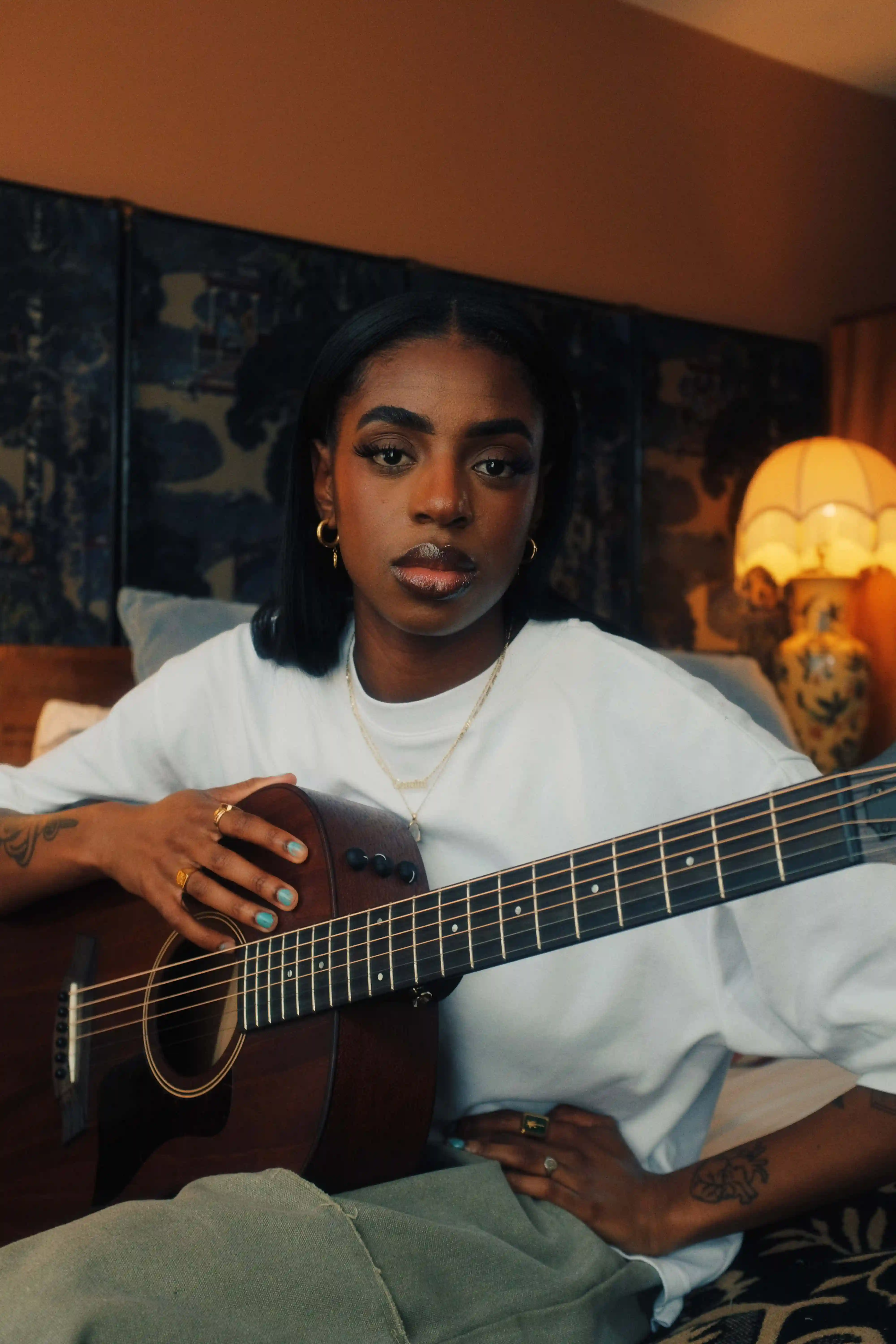 Portrait of Cat Burns with a guitar