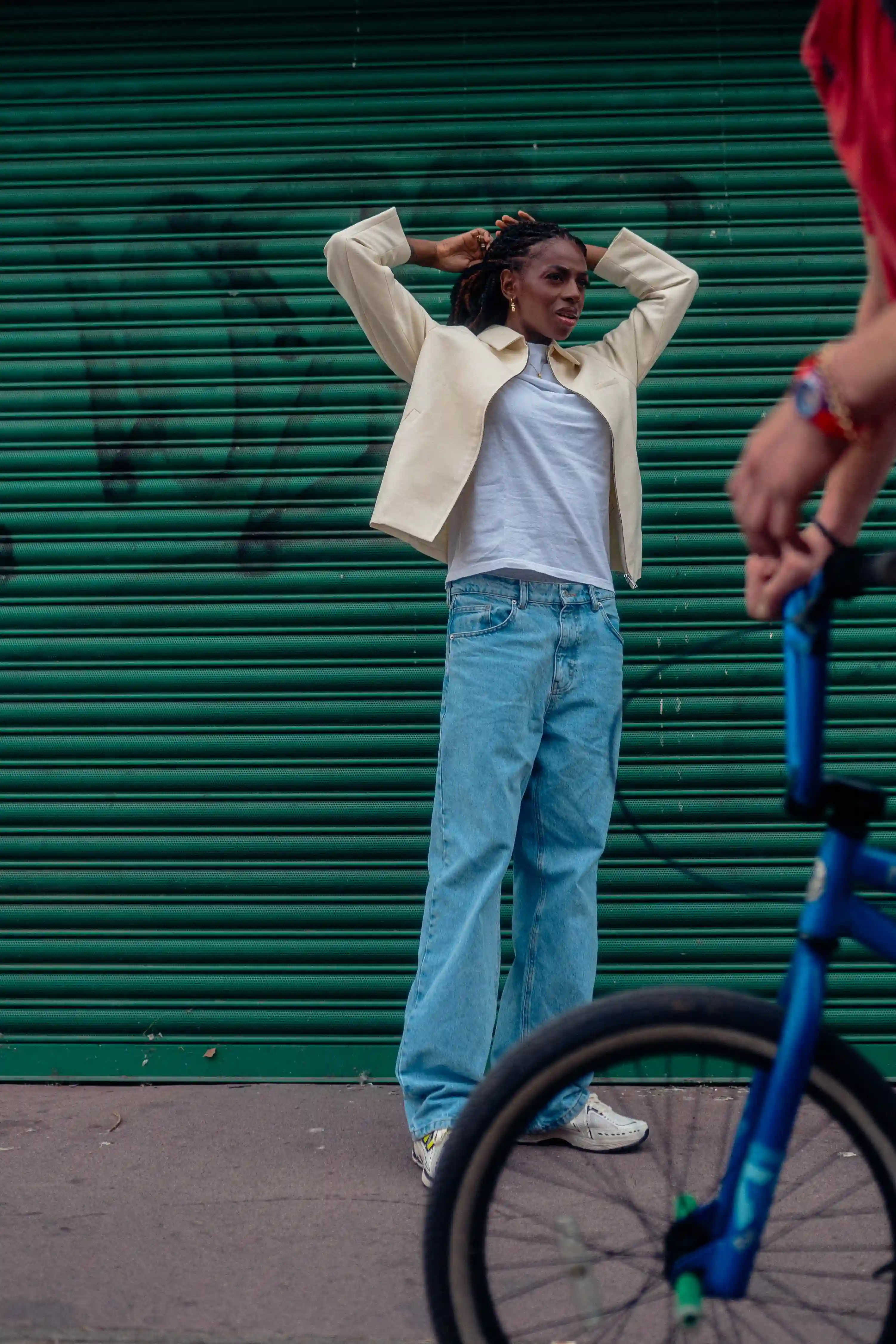 Candid Portrait of Cat Burns with a bicycle passing